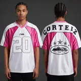 Model wearing Corteiz Fuchsia Fury 20 Jersey, a Touchline Drip football x streetwear jersey