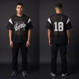 Model wearing Corteiz Open Mesh Panel Jersey Black/white, a Touchline Drip football x streetwear jersey