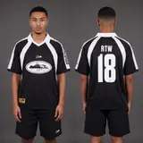 Model wearing Corteiz Black Alcatraz Jersey, a Touchline Drip football x streetwear jersey