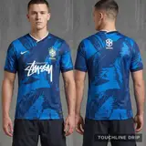 Model wearing Nike x Stussy Brazil Mid Blue Leaf Print Concept Jersey, a Touchline Drip football x streetwear jersey