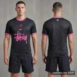 Model wearing Nike x Stussy PSG GTO Black and Pink Jersey, a Touchline Drip football x streetwear jersey