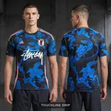 Model wearing Stussy x Japan Mystic Blue-pink Dragon Jersey, a Touchline Drip football x streetwear jersey