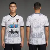 Model wearing Stussy x Japan One Piece White Jersey, a Touchline Drip football x streetwear jersey
