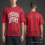 Model wearing Stussy Sport Mesh Jersey - Red, a Touchline Drip football x streetwear jersey