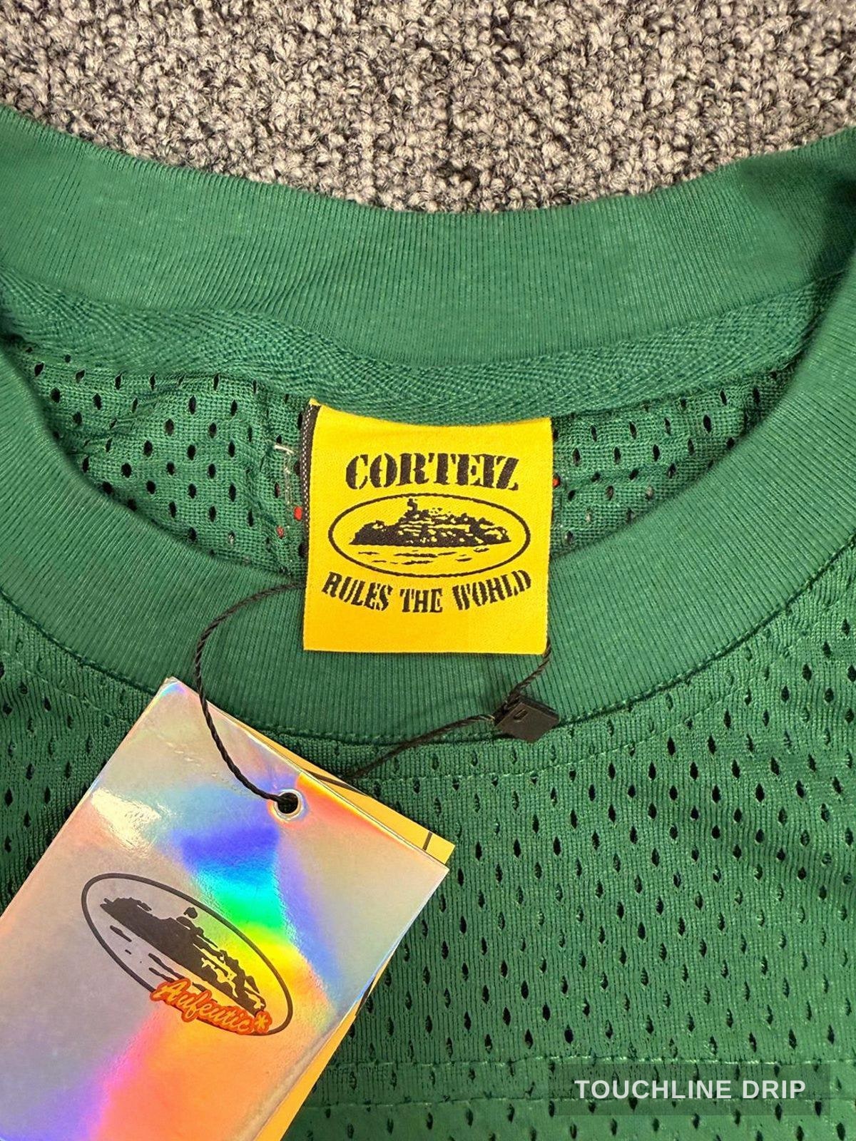 logo closeup product image of Corteiz HMP Mesh Panel Jersey Green